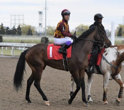 Daisuke Fukumoto riding a horse on a racetrack.